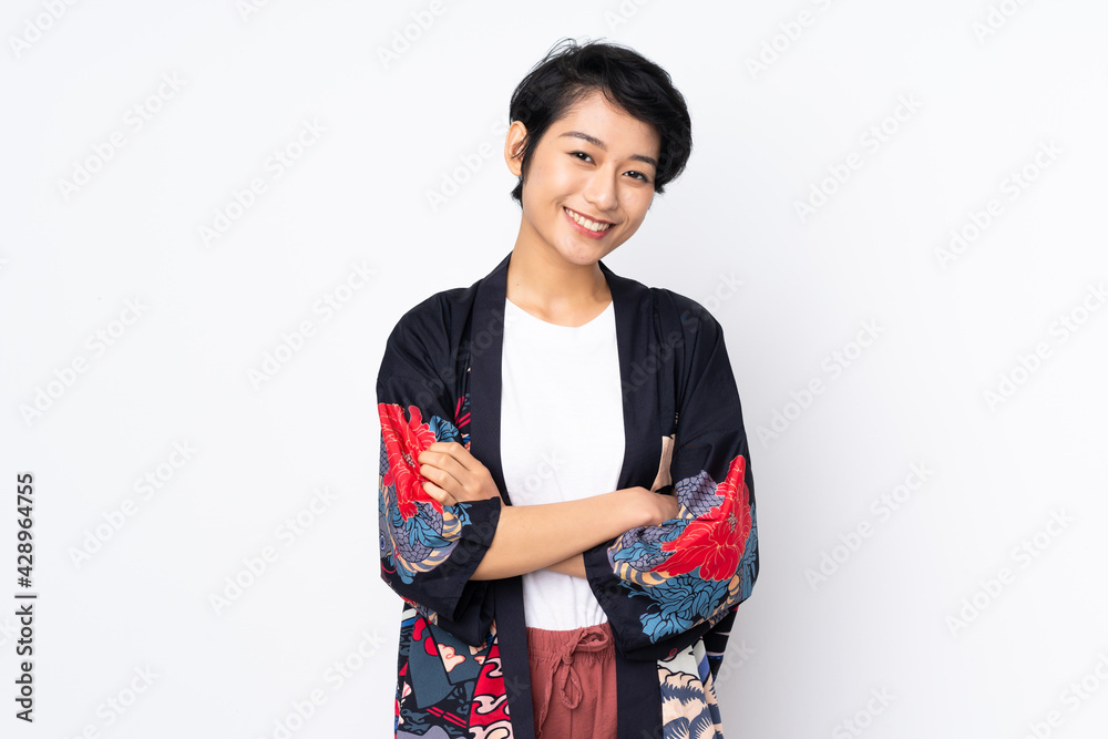 Young Vietnamese woman with short hair wearing a traditional dress over isolated white background smiling a lot Young Vietnamese woman with short hair wearing a traditional dress over isolated white background smiling a lot