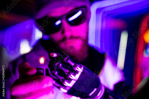 cyber robot hand close up of male handle use lighters going to smoking a cigarette in neon studio