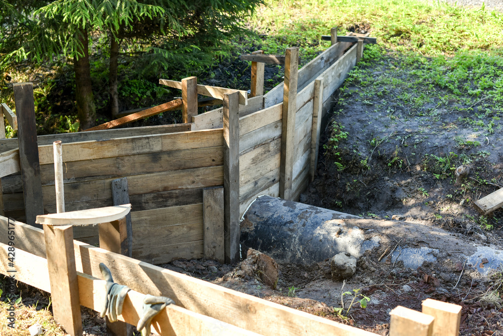 Fototapeta premium Wooden formwork, ready for pouring concrete. Construction of a new site near the house.