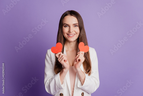 Close up portrait of lady hold two little hearts wear formal suit posing on purple wall
