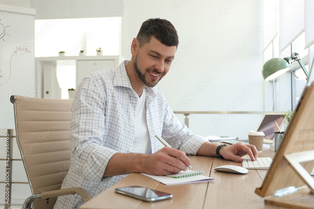 Freelancer working with computer at table indoors Freelancer working with computer at table indoors