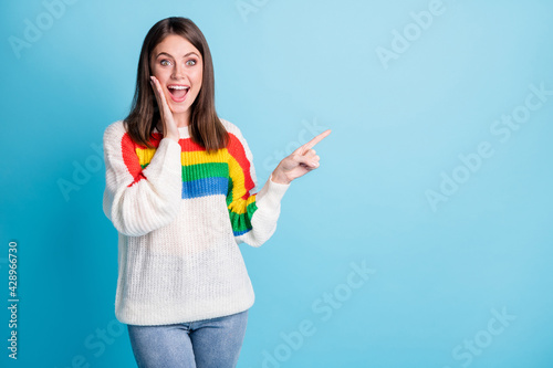 Portrait of attractive cheerful amazed girl demonstrating copy space ad look isolated over bright blue color background