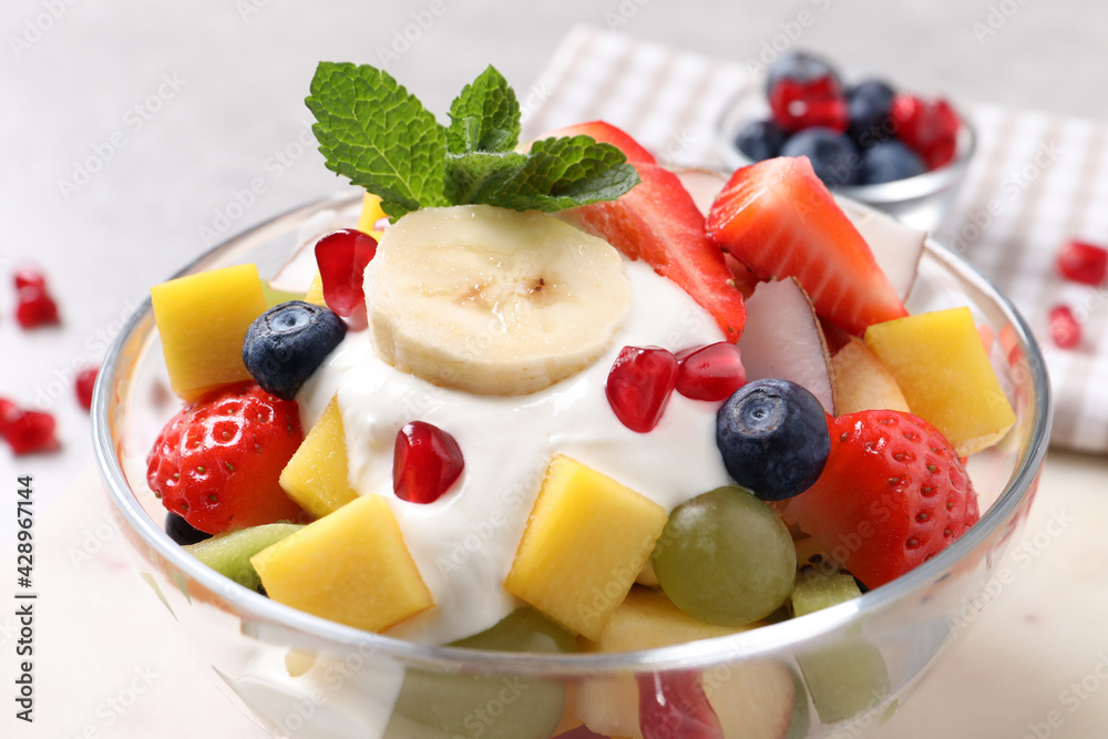 Delicious fruit salad with yogurt in bowl on table, closeup Delicious fruit salad with yogurt in bowl on table, closeup