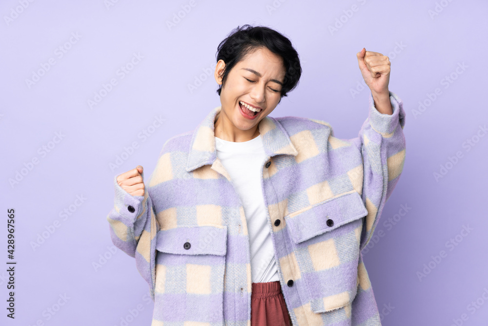 Young Vietnamese woman with short hair over isolated background celebrating a victory Young Vietnamese woman with short hair over isolated background celebrating a victory