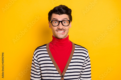 Photo of young man worried nervous bite lips teeth fail mistake problem trouble red turtleneck isolated over yellow color background