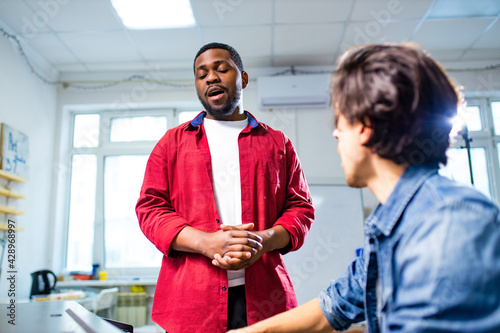 Photography african american student having class with arabian teacher indoors