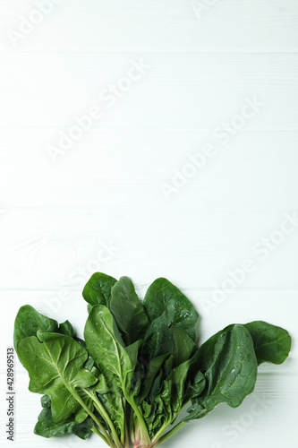 Fresh raw spinach on white wooden background