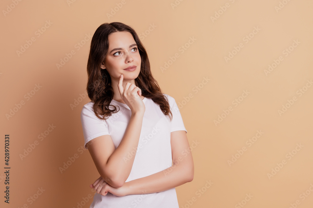 Portrait of thoughtful girl finger cheek look empty space isolated on beige background Portrait of thoughtful girl finger cheek look empty space isolated on beige background