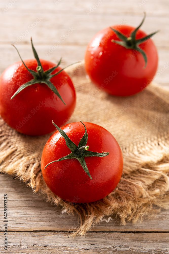 Organic fresh tomatoes on rustic wooden table Organic fresh tomatoes on rustic wooden table