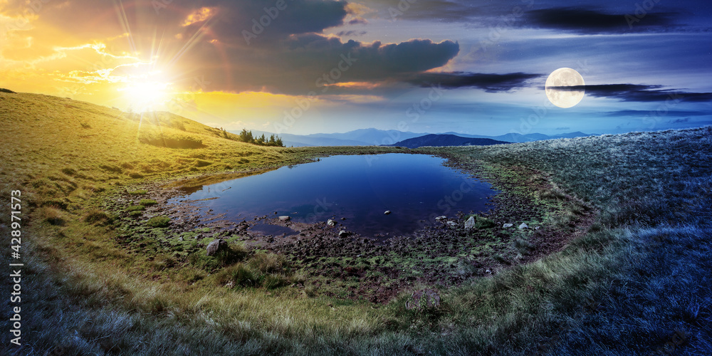 Fototapeta premium day and night time change concept above pond on the mountain meadow. wonderful summer landscape with sun and moon. grass and trees on the hills. ridge in the distance. beautiful wide panorama