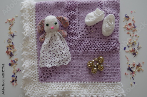 Cadeau de naissance : couverture violette et blanche avec peluche lapin, chaussons et décorations dorées et fleurs séchées