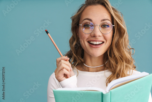 Smiling young woman in glasses holding pencil