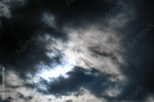 Dramatic dark sky with the sun setting behind black clouds