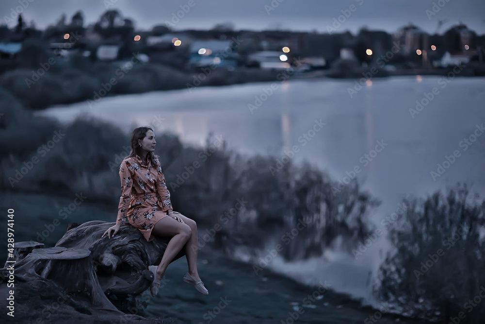 girl river bank sits, concept lonely girl meditates resting river view in the evening
