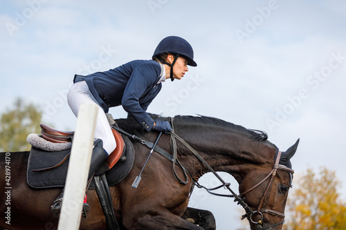 Sportswoman jumps a horse over an obstacle
