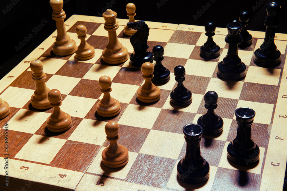 Chess game middlegame, dark background. Retro board and figures from the Soviet Union era Chess game middlegame, dark background. Retro board and figures from the Soviet Union era