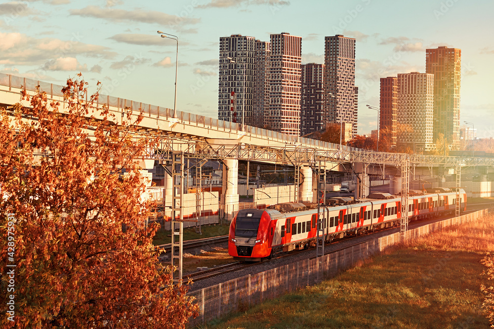 Naklejka premium Passenger train rides by rail in modern city