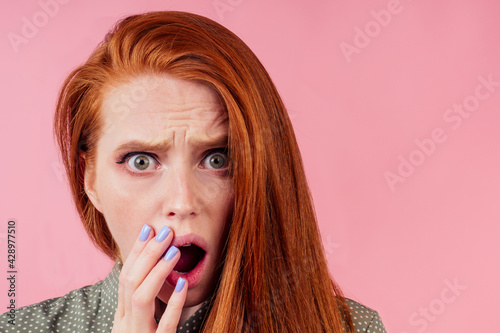 amazed redhair ginger woman worried, fear expression in studio background