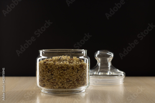 Rice in a glass jar on a black background.