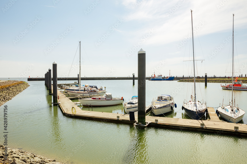 Yacht anchored in the small port.  Travel destinations, sport, amateur recreational sailing. Small yacht boats on the North Sea 