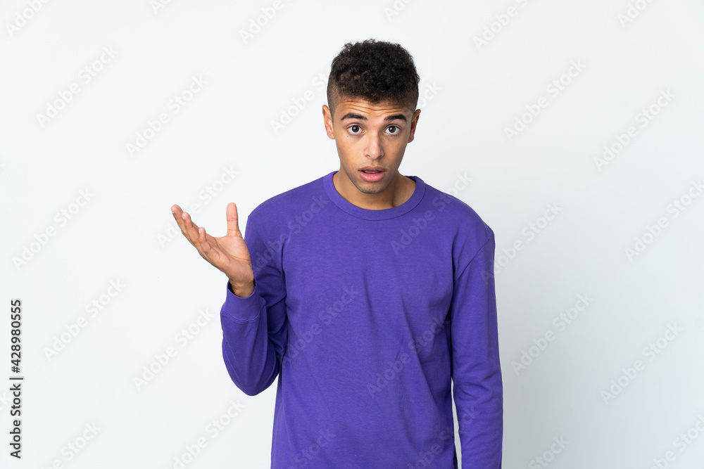 Young brazilian man isolated on white background making doubts gesture Young brazilian man isolated on white background making doubts gesture