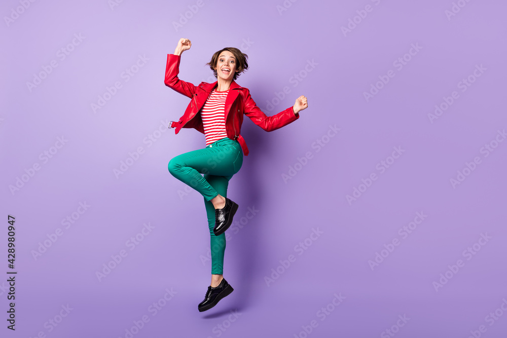 Full size profile side photo of young girl happy smile jump celebrate win victory fists hands isolated over purple color background