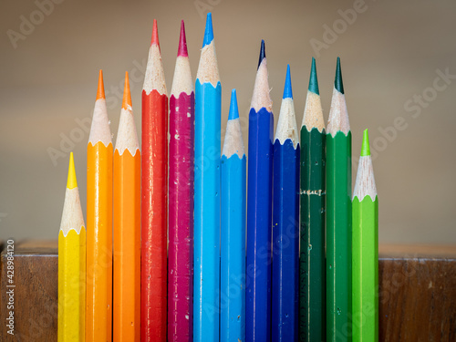 Selective focus. Color pencils in arrange in color wheel colors on wooden table