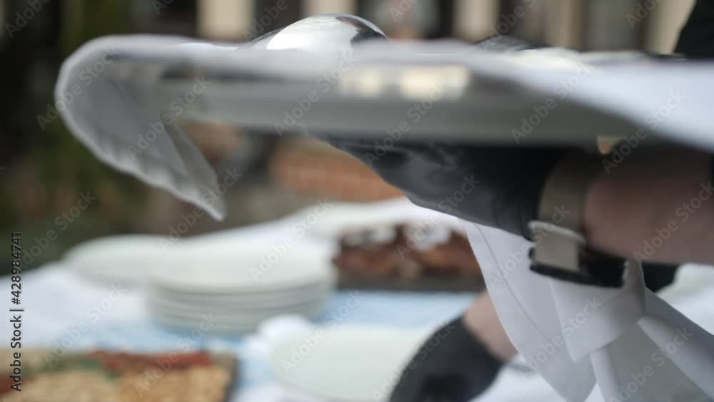 The waiter serves the table. Spoons, forks and knives to lay out on