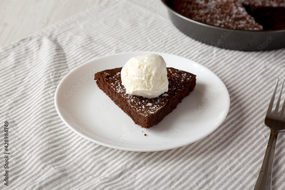 Homemade Chocolate Cake with Ice Cream on a white plate, low angle view. Homemade Chocolate Cake with Ice Cream on a white plate, low angle view.