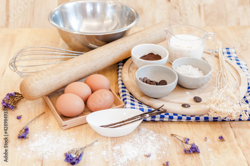Top View Baking Preparation on wooden Table,Baking ingredients. Bowl, eggs and flour, rolling pin and eggshells on wooden board,Baking concept