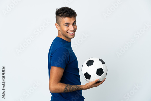 Young Brazilian man over isolated background with soccer ball © luismolinero