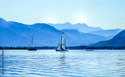 sailing boat on the lake with mountains in the background