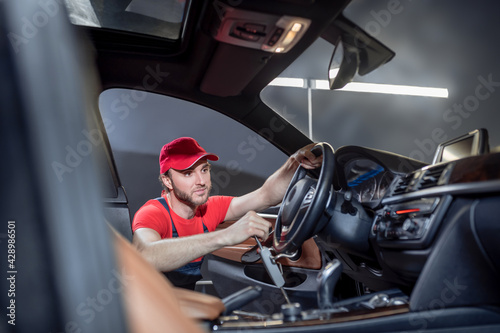 Man in overalls doing car maintenance