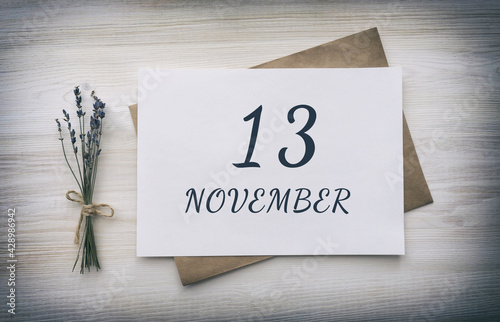 november 13. 13th day of the month, calendar date.White blank of paper with a brown envelope, dry bouquet of lavender flowers on a wooden background. Autumn month, day of the year concept