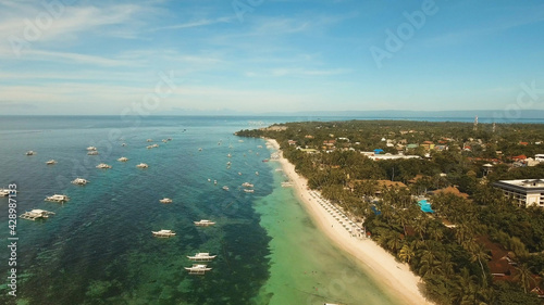 Aerial view of tropica Alona beach on the island Bohol, resort, hotels, Philippines. Beautiful tropical island with sand beach, palm trees. Tropical landscape. Seascape: Ocean, sky, sea. Travel