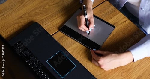 Illustrator hands scetching on tablet computer, using stylus, Creative female graphic designer draw on graphic table, working on creative project at home, Concept of modern art and technology. photo