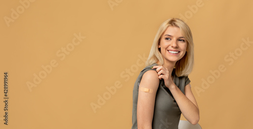 Vaccination saves lives. Happy woman getting vaccinated immunity to covid-19, posing over beige background, panorama
