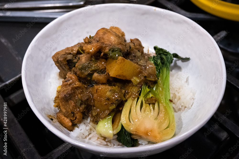 Home-cooked Guyanese curried chicken on white rice with bok choi