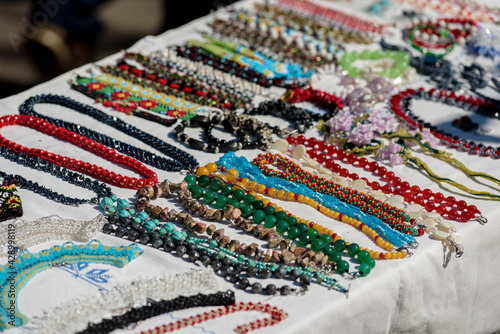 Different ethnic bright necklaces for sale at street market, small business, outdoor street sale autumn fair amid coronavirus pandemic lockdown