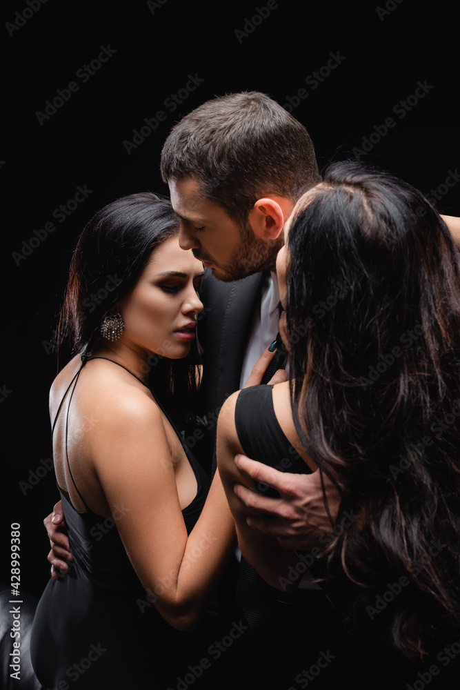 young man embracing brunette women isolated on black. young man embracing brunette women isolated on black.