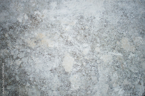 White dirty dusty plain floor surface in a renovated building covered with dust from grinding and painting the walls. White dirty monochrome background. © Patrycja