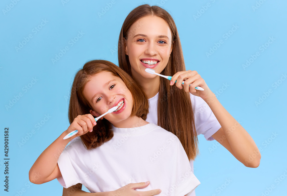 Mother and daughter brushing teeth together Mother and daughter brushing teeth together