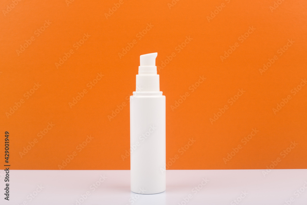 Face or neck cream with citrus extracts on white table against orange background with copy space. Concept of organic skin care with fruit oils and natural ingredients Face or neck cream with citrus extracts on white table against orange background with copy space. Concept of organic skin care with fruit oils and natural ingredients
