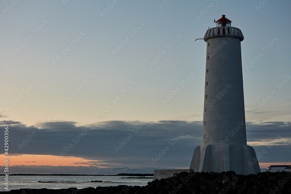 White high lighthouse in Akranes town at sunset Iceland