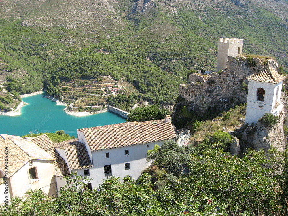 view of the old houses and roofs from above in mountains. view of the blue mountain lake. Guadlest. Spain