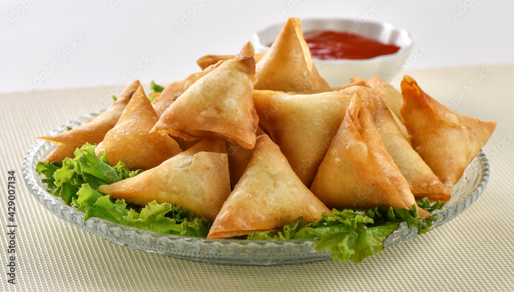 Chicken and Vegetable Samosa, Pakistan and India's most eating snack. Triangle Shape Crunchy Wraps and stuffed with vegetables and chicken. Chicken and Vegetable Samosa, Pakistan and India's most eating snack. Triangle Shape Crunchy Wraps and stuffed with vegetables and chicken.