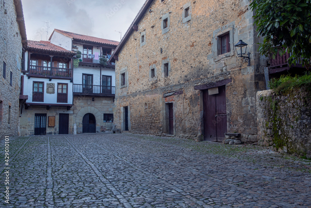 Medieval and lonely street with cobbled floor in the famous and touristic town of Santillana del Mar, in the Cantabria region of Spain