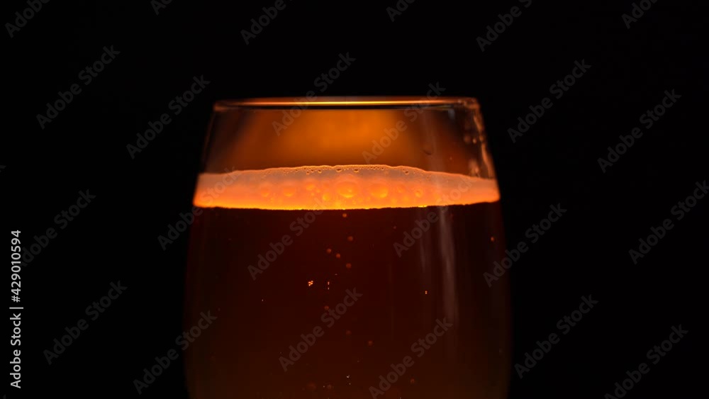 Glass Filled With Light Beer. Light Beer Into a Glass on a Dark Background Glass Filled With Light Beer. Light Beer Into a Glass on a Dark Background