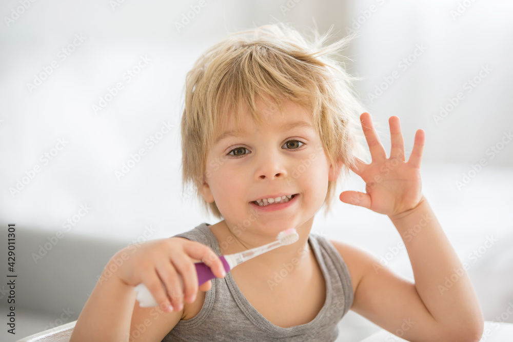 Cute toddler child, blond boy, brushing his teeth at home Cute toddler child, blond boy, brushing his teeth at home