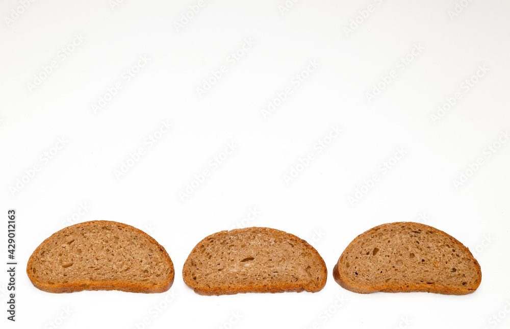 pieces of black bread from coarse flour on a white background pieces of black bread from coarse flour on a white background